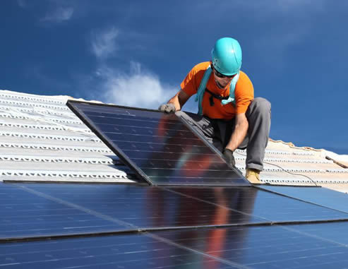 Photo of worker installing solar panels